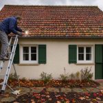 Maison individuelle au toit en tuiles inspectée avant l’hiver, entourée de feuilles d’automne sous un ciel nuageux.
